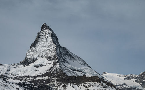 Low angle view of snowcapped mountain against sky