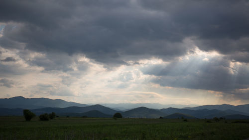 Scenic view of landscape against storm clouds