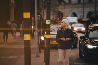 Senior woman looking away while walking in city