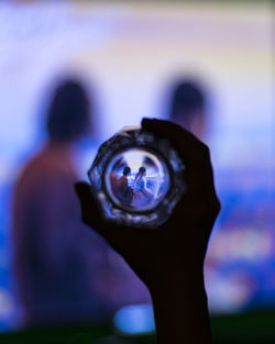Close-up of man photographing illuminated camera