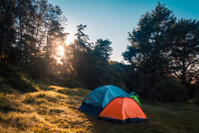 Tent on field against bright sun in sky