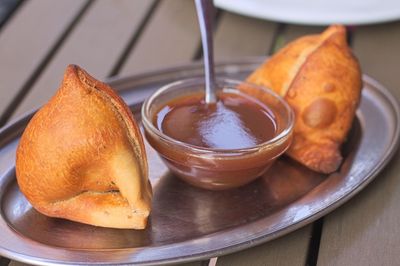 Close-up of samosa and chutney served in tray on table