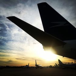 Low angle view of silhouette airplane against sky during sunset