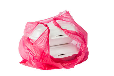 Close-up of white boxes in pink plastic over white background