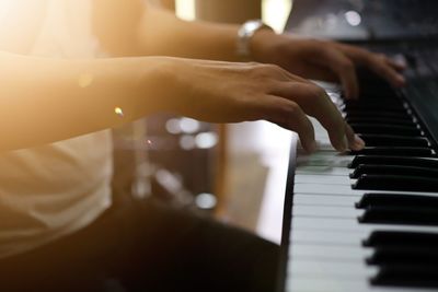 Midsection of pianist playing piano