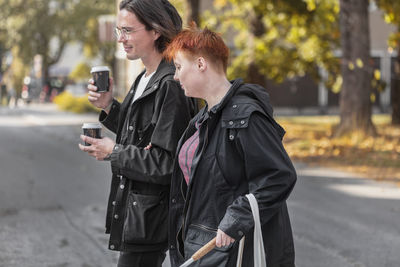 Visually impaired woman walking in street with male friend