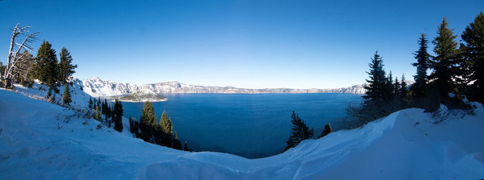 Scenic view of snow covered mountains against clear blue sky