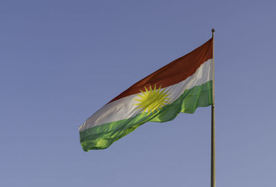 Low angle view of flag against clear blue sky