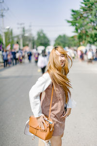 Portrait of smiling young woman standing on street