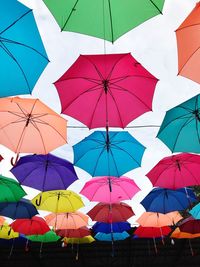 Low angle view of umbrellas hanging against sky