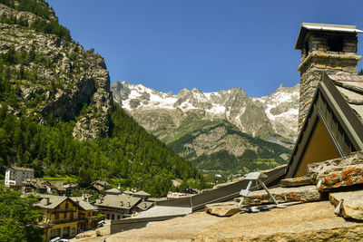 Houses by trees and mountains against sky