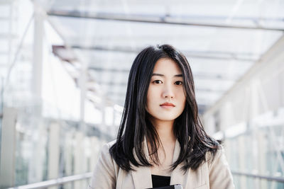 Portrait of confident chinese business woman in building office. technology