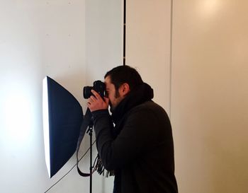 Side view of man photographing in studio