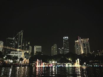 Illuminated cityscape against clear sky at night