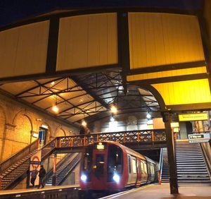 Low angle view of illuminated railroad station at night