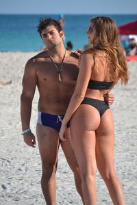 Couple embracing while standing at beach