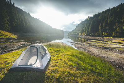 Tent at lakeshore against trees