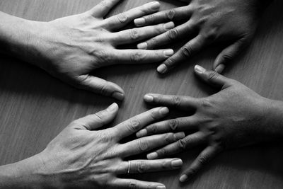 Cropped hands of friends on table