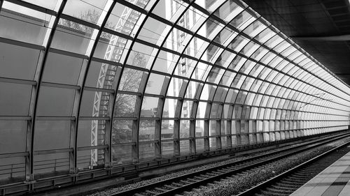 Railway tracks by glass wall