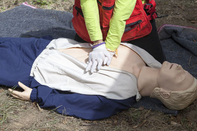 Midsection of paramedic performing cpr on mannequin