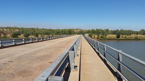 Bridge over river against clear blue sky