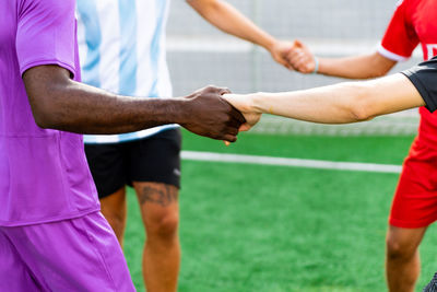 Cropped image of players holding hands outdoors