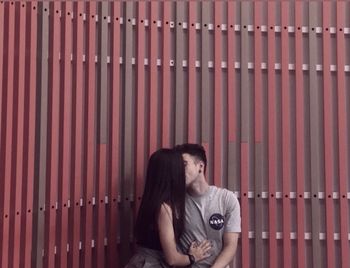 Portrait of young woman sitting on metal structure