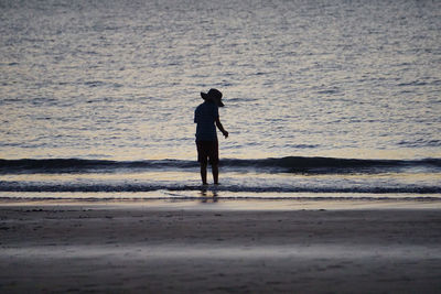 Rear view of man standing on beach