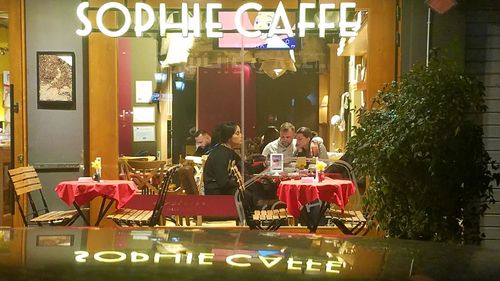 People sitting in illuminated city at night