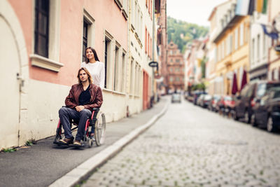 People sitting on street in city