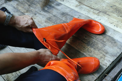 Low section of man wearing orange boots
