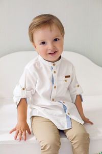 Child sitting on a wooden white cart in the studio as a birthday decoration