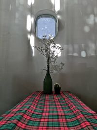 Illuminated electric lamp on table by window