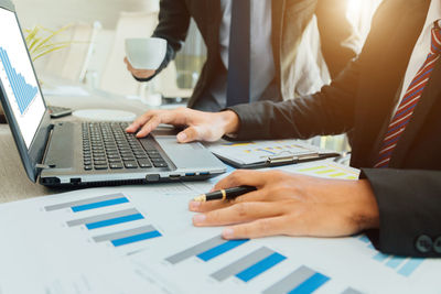 Midsection of man using laptop on table