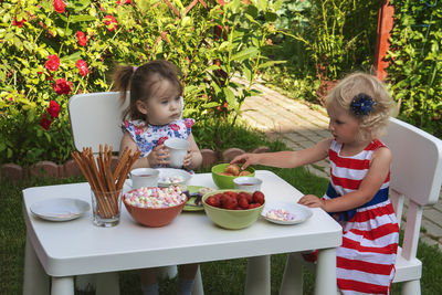 Cute girl sitting with food on table