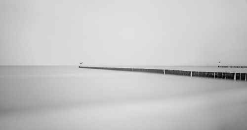 Pier over sea against clear sky