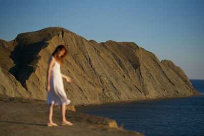 Full length of woman on beach against clear sky