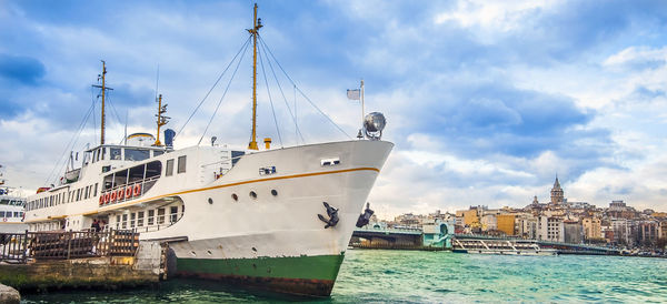 Boats moored on sea against buildings in city