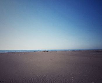 Scenic view of beach against clear blue sky