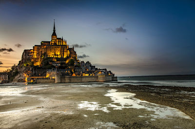 View of building at beach during sunset