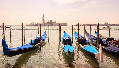 Gondolas moored in canal during sunset