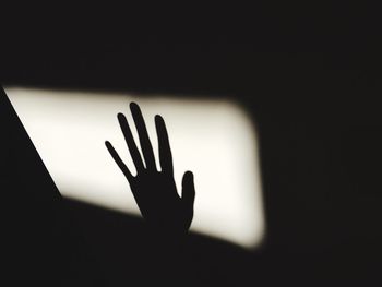 Close-up of hand touching silhouette