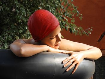 Woman relaxing in bath tub against plants