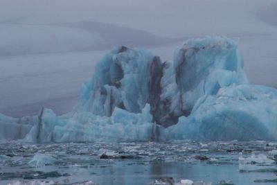 Ice floating on sea against sky during winter