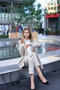 Young woman using mobile phone in city