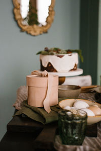 Round gift box on a set festive table on the background of a cake