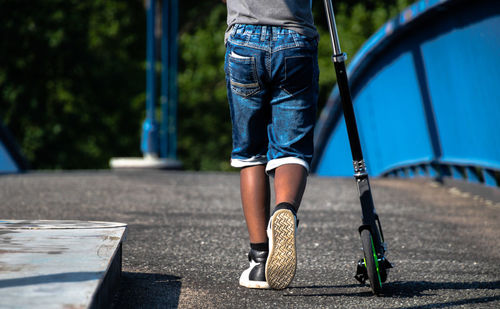 Low section of child standing on skateboard
