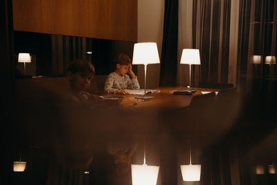 Brothers studying at table in home