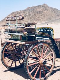 View of old cart on field against mountain