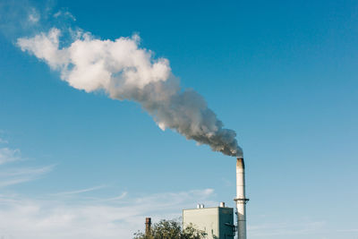 Smoke emitting from chimney against sky